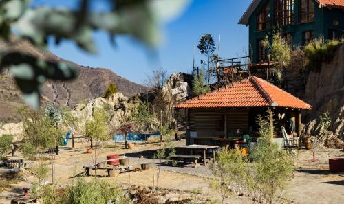 ラパスにあるColibrí Eco Lodge & Campingの山の隣のオレンジ瓦屋根の建物