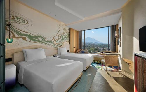 万隆Hotel Indigo Bandung Dago Pakar by IHG的有两张床和一张书桌的酒店房间