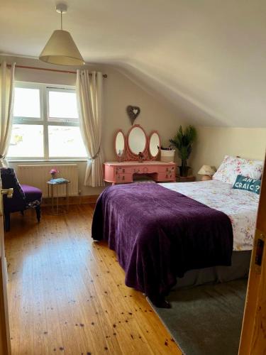 a bedroom with a bed and a dresser with mirrors at The Burren Coach House in Bealaclugga