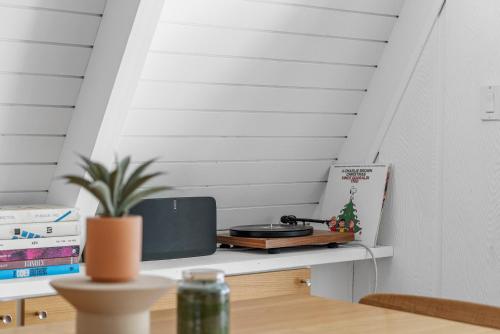 a room with a table with a tv on a shelf at Luxury A-Frame Retreat in Lake Arrowhead