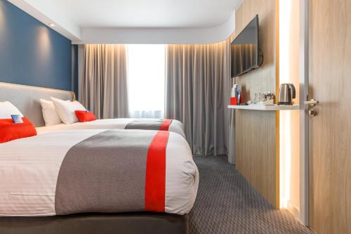 a hotel room with a bed and a television at Holiday Inn Express - Bodmin - Victoria Junction by IHG in Bodmin