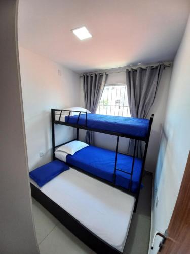 two bunk beds in a room with a window at Casa Climatizada com Piscina em Jacaraipe in Serra