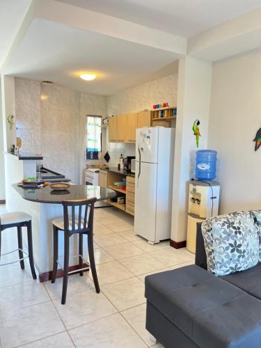 a kitchen with a table and a white refrigerator at Ocean view apart inteiro lazer privativa in Nísia Floresta