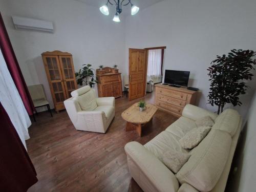a living room with a couch and two chairs and a table at Fókusz Apartman Pécs in Pécs