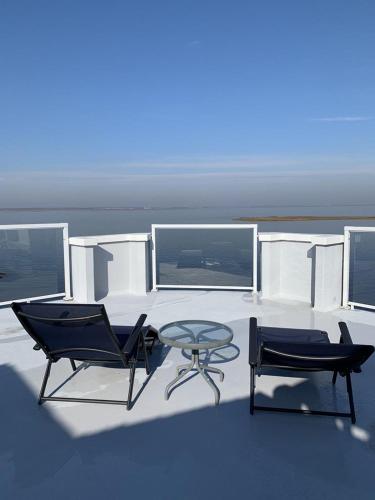 two chairs and a table on a boat at Pet Friendly Ocean And Bay Views Wifi Rooftop Deck Beach Badges Streaming Tvs Deck Os Private Yard Beach Chairs Beach Badges in North Beach