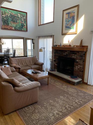 a living room with a couch and a fireplace at Pet Friendly Ocean And Bay Views Wifi Rooftop Deck Beach Badges Streaming Tvs Deck Os Private Yard Beach Chairs Beach Badges in North Beach