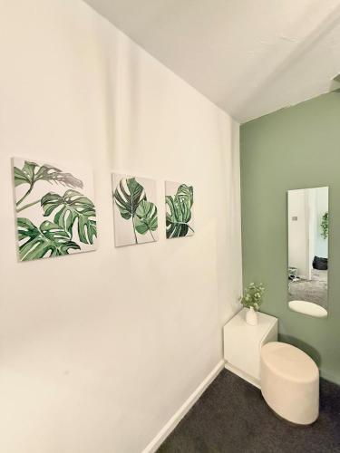 a bathroom with three paintings on the wall at Watford Stay Comfortable Home Near Town Centre and Transport in Watford