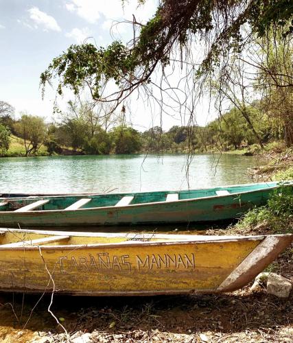 two boats sitting on the side of a river at Cabañas Mannan in Tanchachín