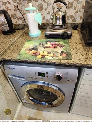 a washing machine in a kitchen with a picture on it at HOTEL Mansoura University Private in Mansoura