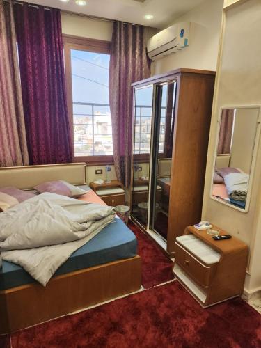 a small bedroom with a bed and a mirror at HOTEL Mansoura University Private in Mansoura
