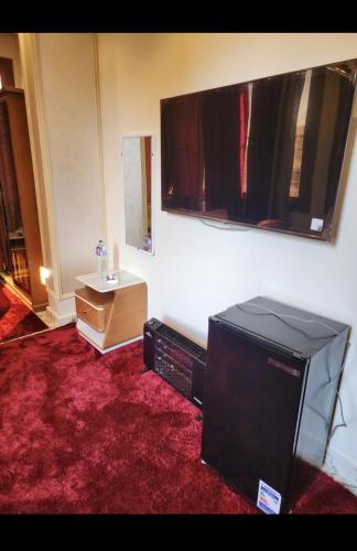 a living room with a television and a desk with a mirror at HOTEL Mansoura University Private in Mansoura