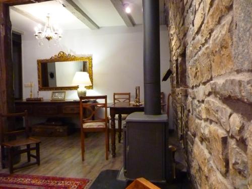 a living room with a stone wall and a wood stove at Kapel Etxea in Urzainqui