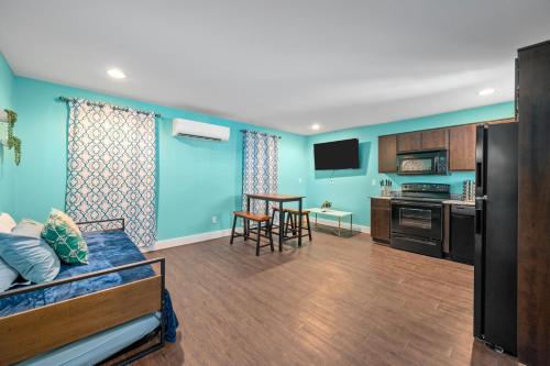 a living room with blue walls and a kitchen at Chic Comfort Near Houston Hotspots in Houston