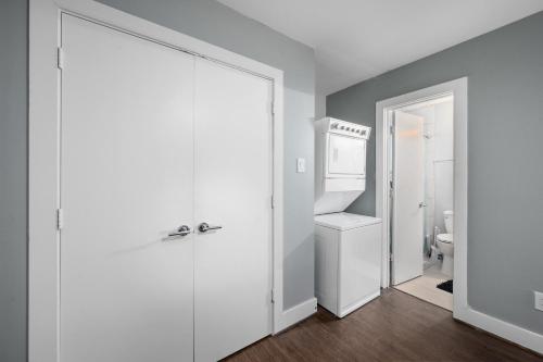 a bathroom with a white door and a toilet at Chic Comfort Near Houston Hotspots in Houston