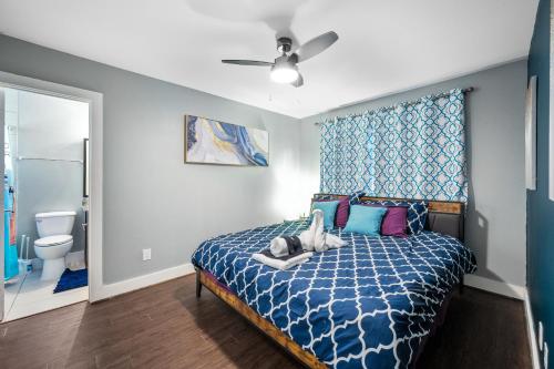 a bedroom with a bed with a blue comforter at Chic Comfort Near Houston Hotspots in Houston