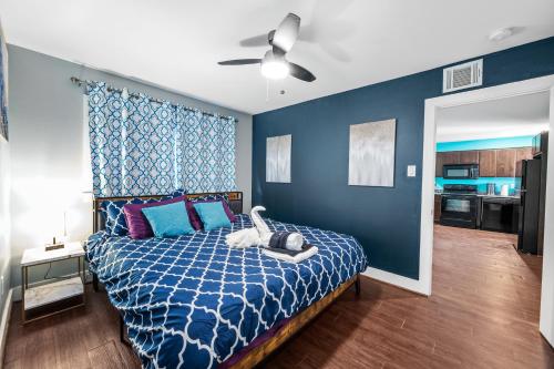 a bedroom with a bed and a blue wall at Chic Comfort Near Houston Hotspots in Houston