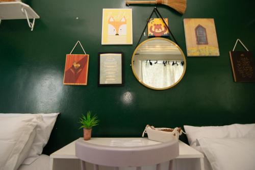a green wall with a mirror and a table at Happiness House Hospedagem in Cuiabá