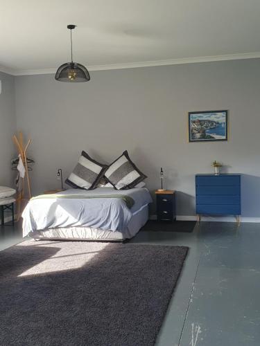 a bedroom with a bed and a blue cabinet at The Red Shed in Matamata