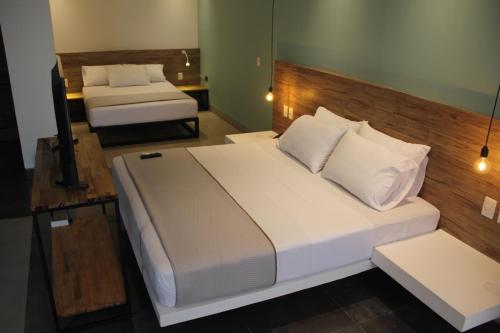 a hotel room with two beds and a television at G Hotel by Gaya Group in Santa Cruz de la Sierra