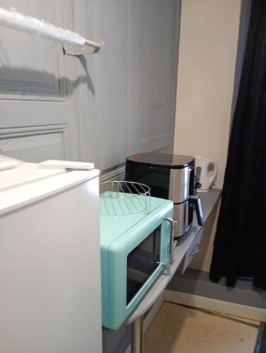 un micro-ondes posé sur un comptoir dans une cuisine dans l'établissement Duplex Center Thiers - Clermont-Ferrand - Lyon - Free Parking - Self-check-in, à Thiers