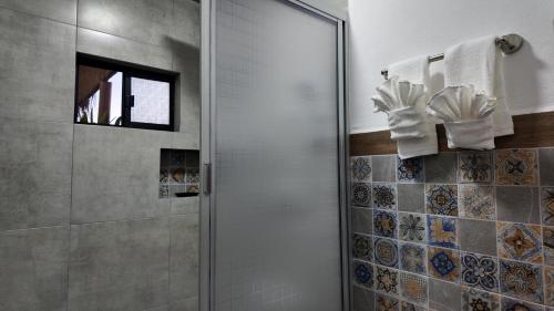 Un baño con ducha con puerta de cristal. en MarJor Suites, en La Paz