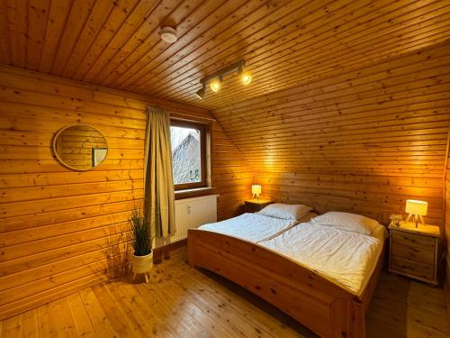 a bedroom with a bed in a wooden room at Feriendorf Blauvogel Blauvogel 040 in Hasselfelde