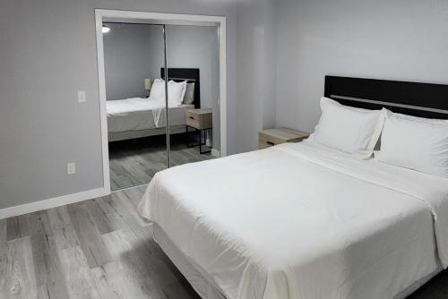 a bedroom with a large white bed and a mirror at Peaceful Midtown Apartment with Gym and Parking in Tulsa