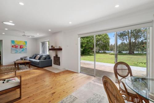 a living room with a glass table and a couch at Cosy Creekside in Dora Creek