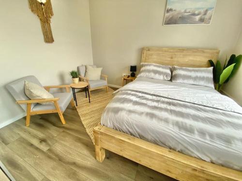 a bedroom with a wooden bed and a chair at The Beach Side Micro Apartment With Free Parking in Blacksmiths