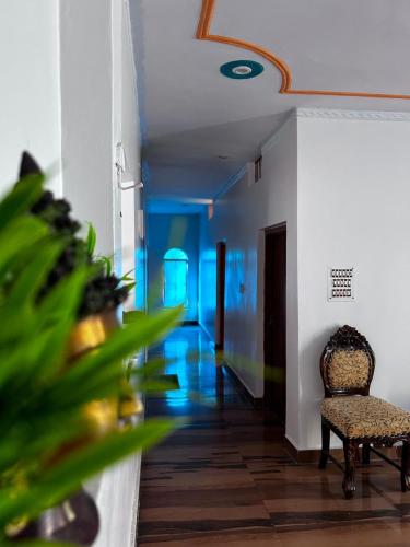 a hallway with a chair and a room with blue lights at Lamyali Farm in Rishīkesh