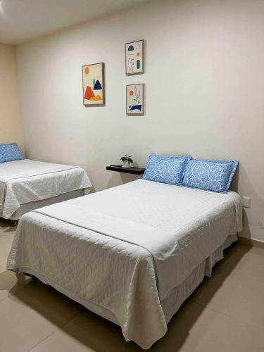a bedroom with two beds with blue pillows at Casa Soly in Mazatlán