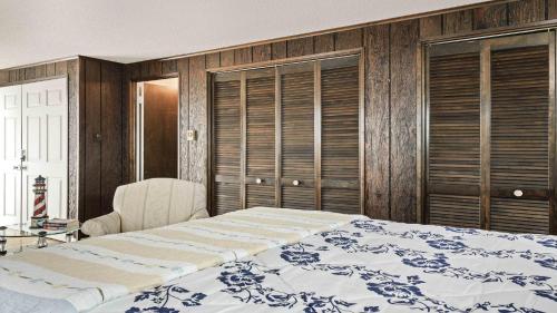 a bedroom with a large bed and wooden walls at Wi-Fi, Yes To Pets, Patio, Private Yard, Beach Chairs,balcony, Beach Badges, Outside Shower, Decks,,large 5 Bedroom 2 Bath Bayside Cape, in Ship Bottom