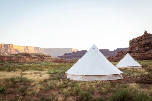 two tents in a field with mountains in the background at Glamping Family Tent At Private Riverside Ranch in Moab