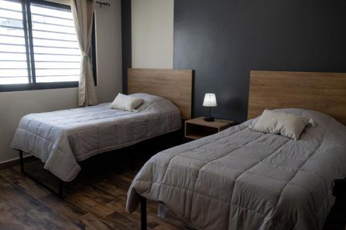 アグアスカリエンテスにあるDepartamento cómodo, moderno y funcional excelente ubicaciónのベッド2台と窓のある寝室