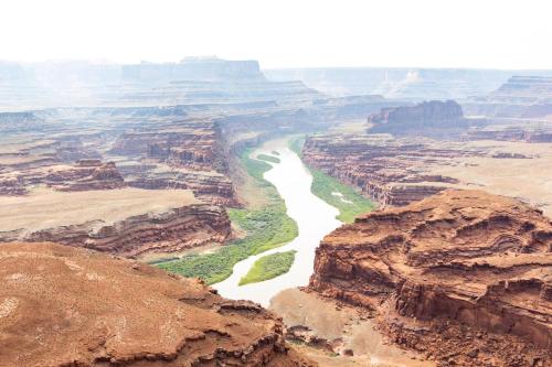 a view of the grand canyon from the top of a cliff at The Caves at Moab - At Private Riverside Ranch in Moab