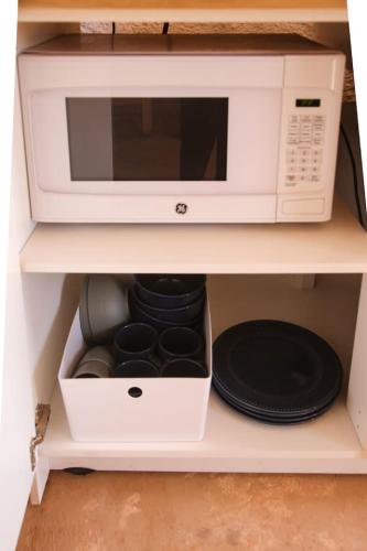 a microwave sitting on top of a shelf at The Caves at Moab - At Private Riverside Ranch in Moab