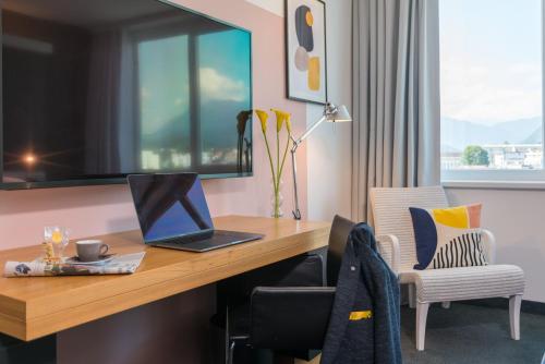 a desk with a laptop computer on top of it at voco Villach by IHG in Villach