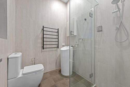 a bathroom with a toilet and a glass shower at The Sands on Margate Beach in Woody Point