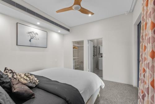 a bedroom with a bed and a ceiling fan at The Sands on Margate Beach in Woody Point