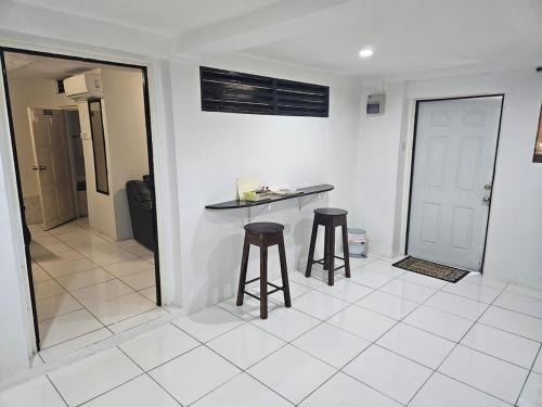 a kitchen with two stools and a counter in a room at LADVILLE Apartment near Kingstown #1 in Kingstown