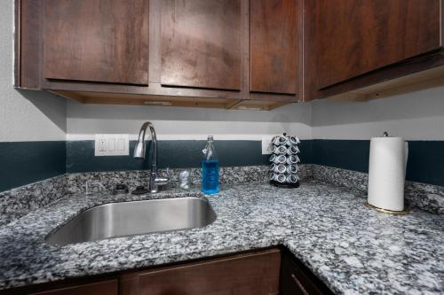 a kitchen counter with a sink and wooden cabinets at Quirky 1BR Near NRG Stadium & Medical Center in Houston