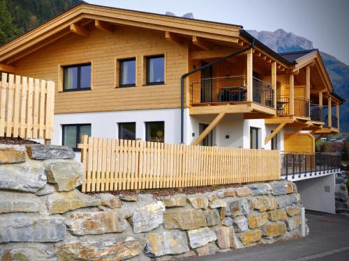 a house with a stone wall in front of it at Bergblick in Werfenweng
