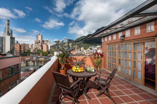a patio with a table and chairs on a balcony at Hotel Casa Deco in Bogotá