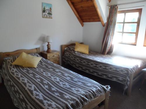 a bedroom with two beds and a window at Cabaña Ruca Kushe in Lago Puelo