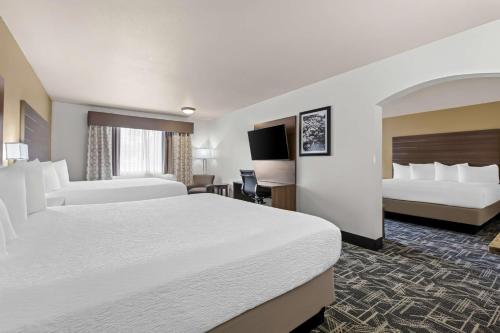a hotel room with two beds and a television at Best Western Plus Caldwell Inn & Suites in Caldwell