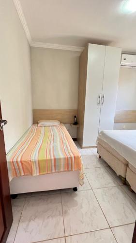 a small bedroom with two beds and a cabinet at Ocean view apart inteiro lazer privativa in Nísia Floresta
