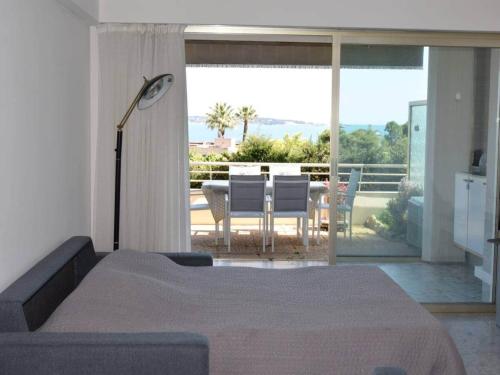une chambre avec un lit et un balcon avec une table et des chaises dans l'établissement Apartment in Golfe Juan with Sea View, à Vallauris