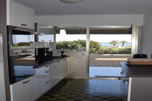 une grande cuisine blanche avec vue sur l'océan dans l'établissement Apartment in Golfe Juan with Sea View, à Vallauris