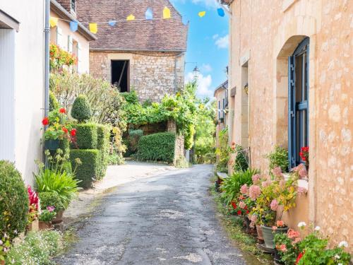 an alley in an italian village with flowers at Charming Holiday Home with Private Pool in Hautefort