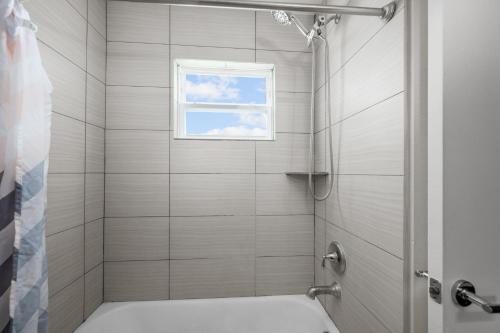 a bathroom with a shower with a window at Cozy Sanctuary Near MedCenter, UH and NRG in Houston